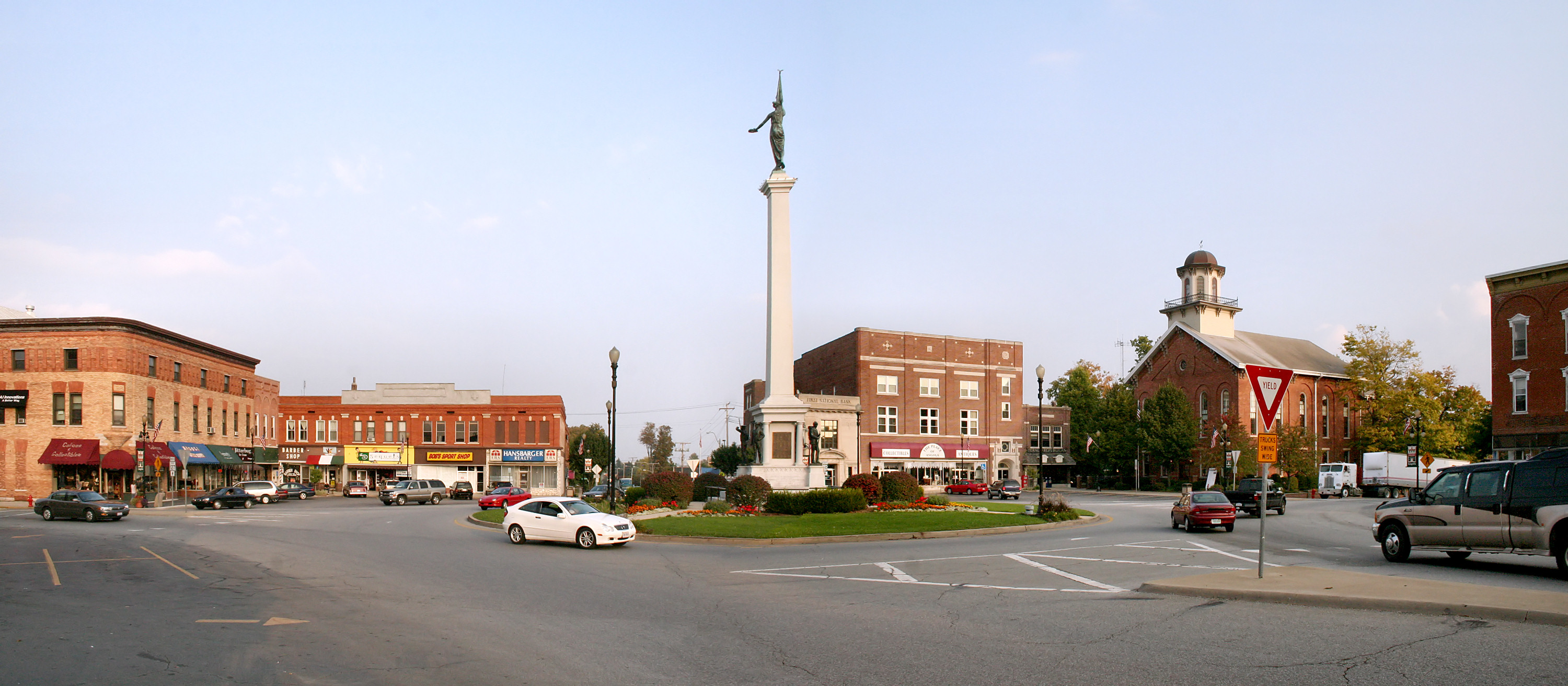 Downtown Angola Indiana historic square with soldier monument in roundabout surrounded by brick buildings and local shops in the heart of Steuben County
